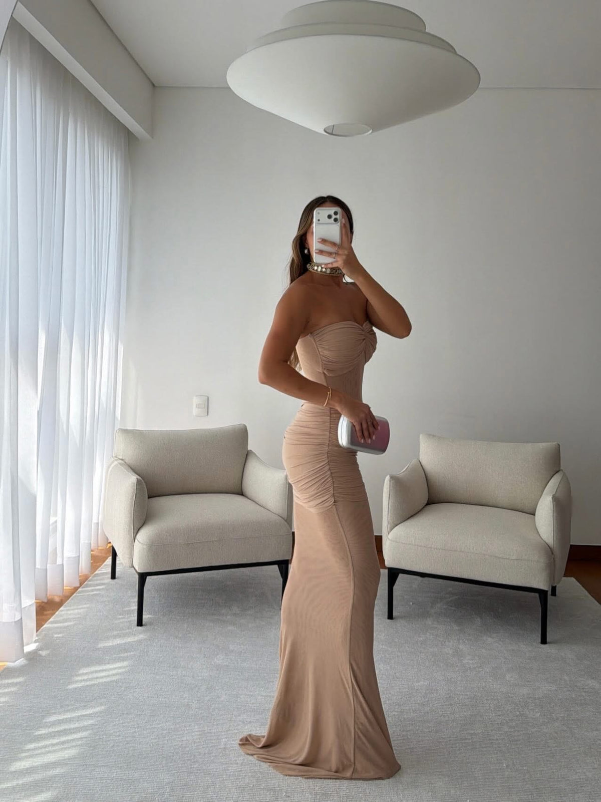 Vista lateral de vestido largo beige strapless con silueta entallada