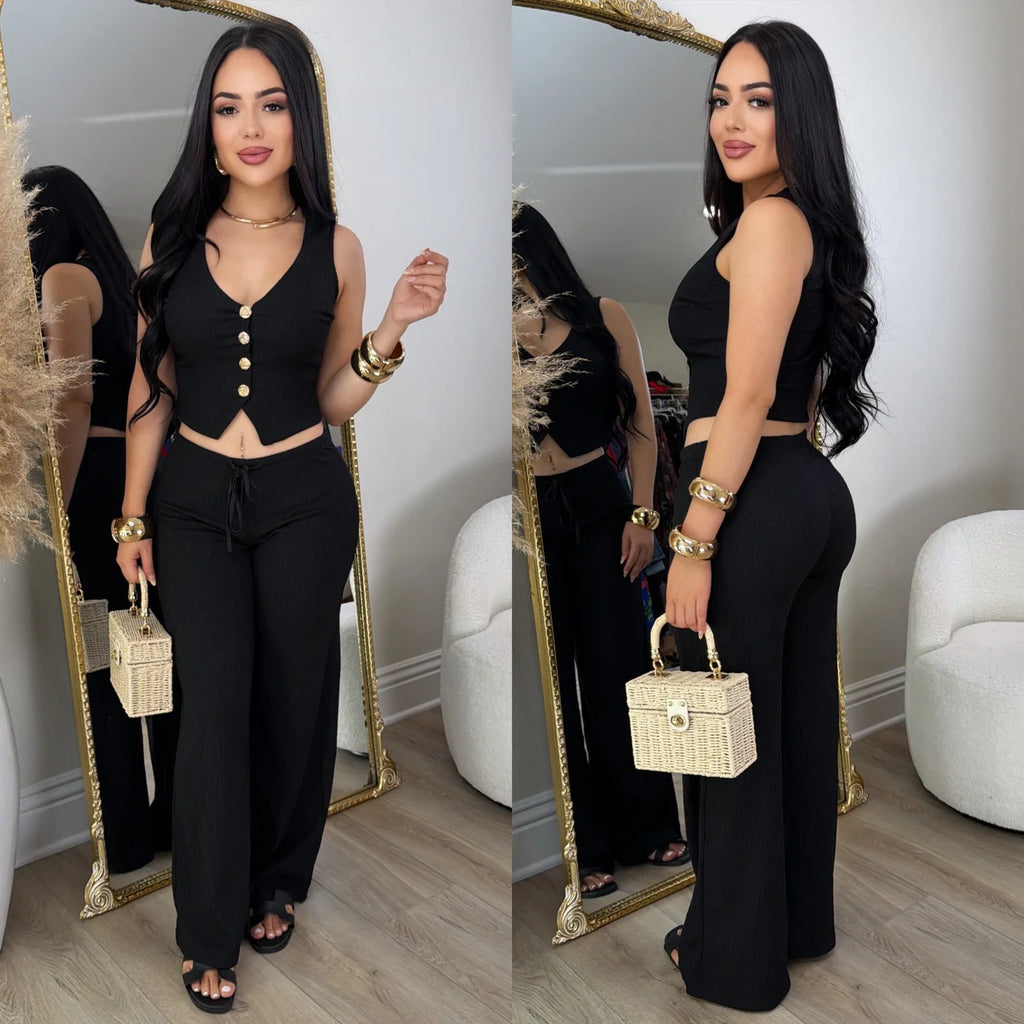 Conjunto negro de chaleco con botones dorados y pantalón amplio