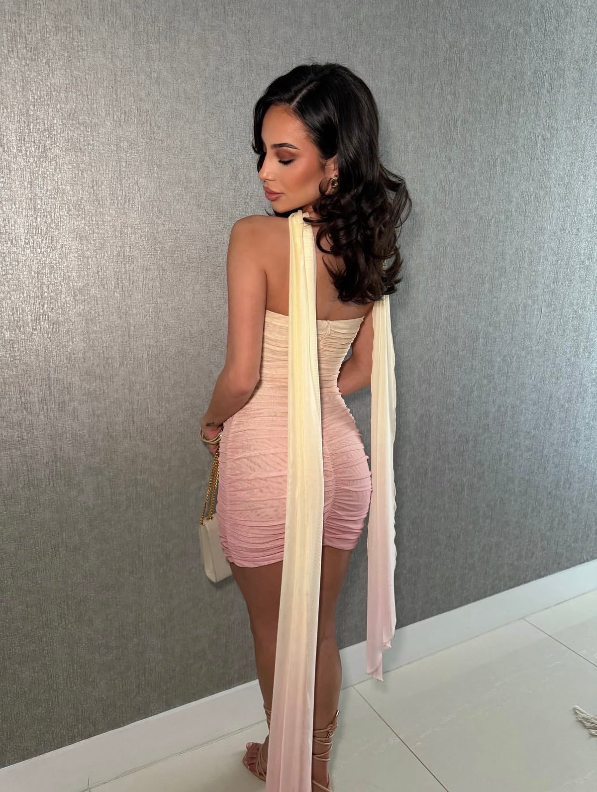 Vista posterior del vestido corto degradado crema y rosa con banda larga al cuello