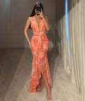 Vista frontal de vestido largo estampado coral con cuello halter, drapeado y volantes