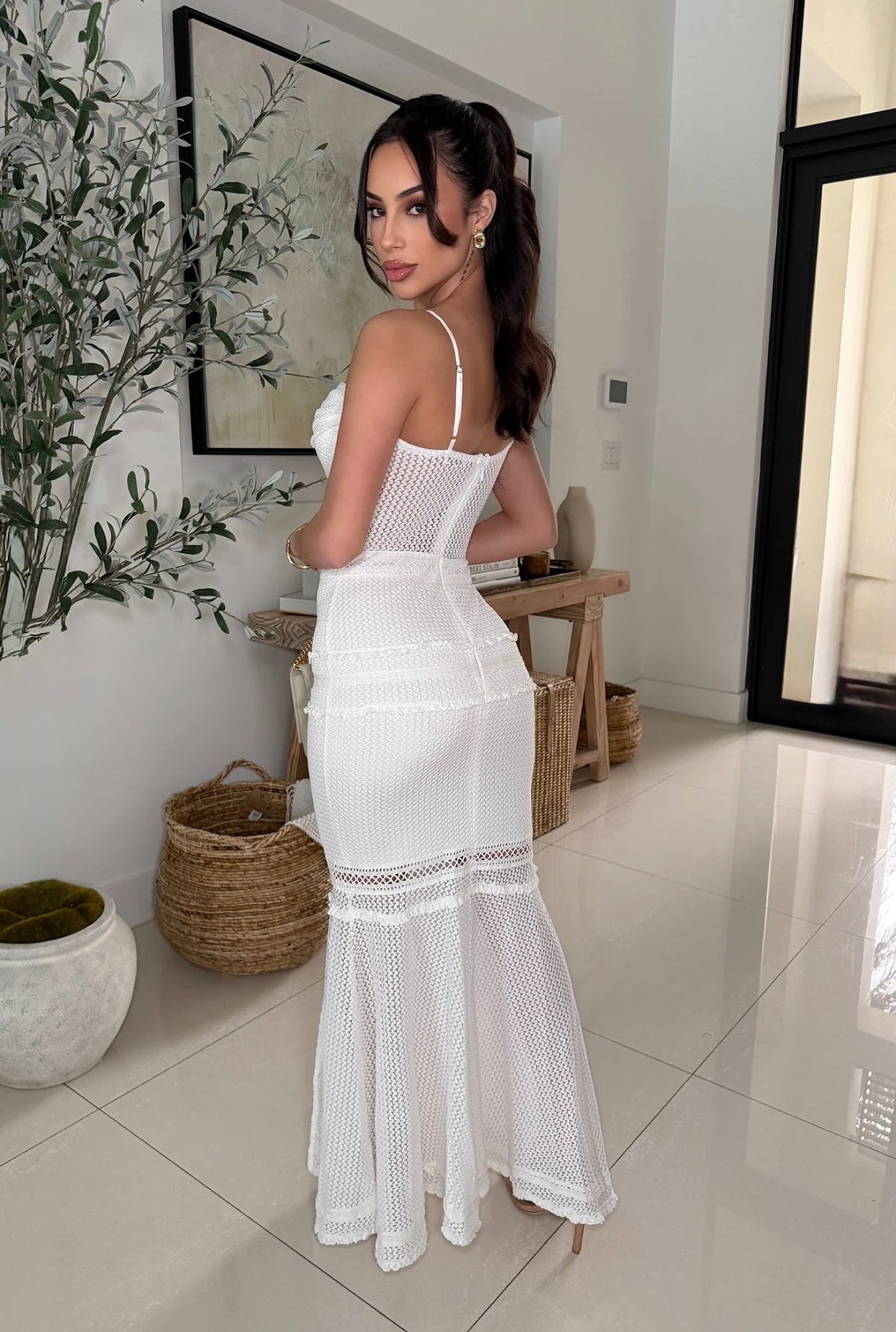 Vista posterior de vestido largo blanco de tirantes con transparencias y falda sirena