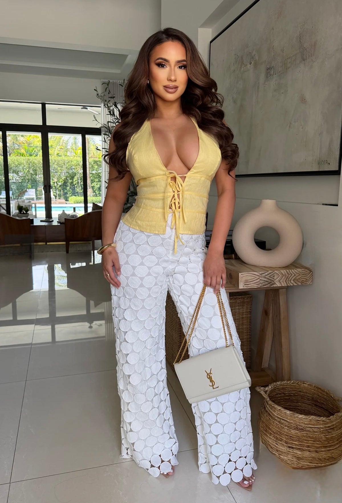 Blusa amarilla halter con escote profundo y lazo frontal; pantalón y accesorios no incluidos